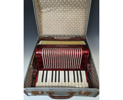 A vintage Hohner Student II Accordion, with red marbled-effect body, in carry case. 