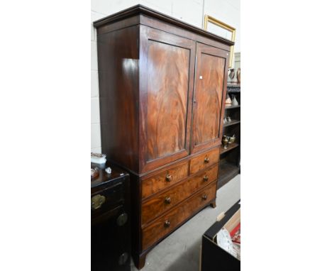A Regency mahogany linen-press, the panelled doors enclosing five slides over two short and two long drawers raised on splaye