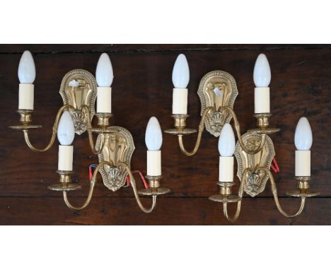 Four brass twin-branch wall sconces with beaded wall plates 