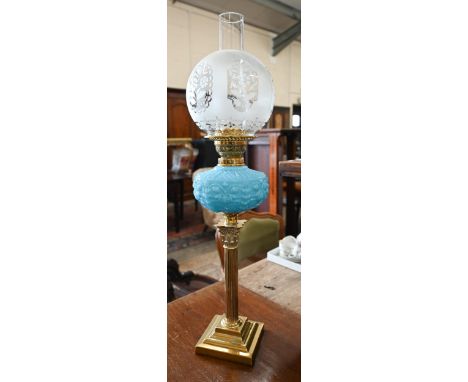 A Victorian brass oil lamp with etched globe shade, blue pressed glass font and classical pillar, 72 cm high overall 