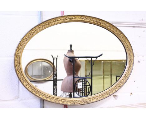 A gilt framed oval mirror.