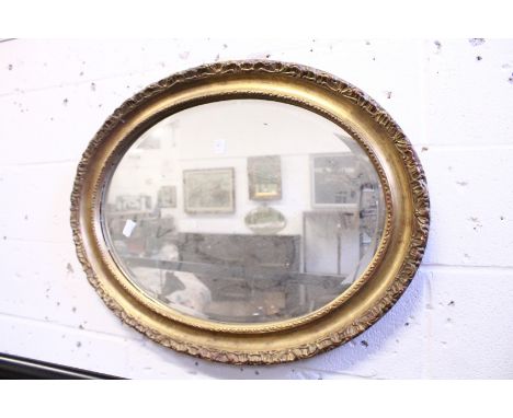 A gilt framed oval wall mirror.