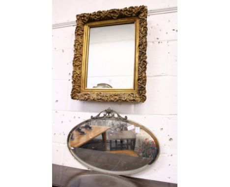 A gilt framed mirror and an oval mirror.
