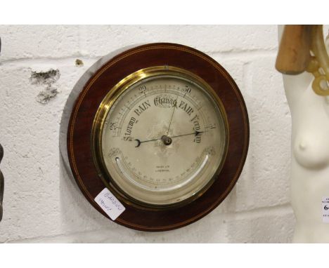 A mahogany cased circular barometer and thermometer.