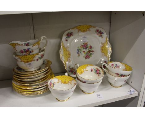 A Paragon part tea service decorated with yellow panels and exotic birds.