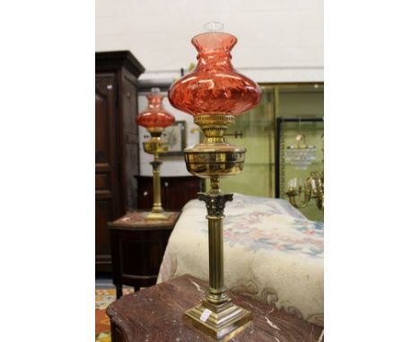 A good pair of Corinthian column brass oil lamps with ruby coloured shades.