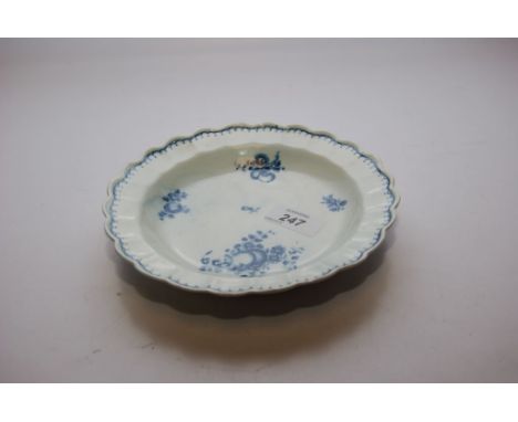 A WORCESTER BLUE AND WHITE PLATE WITH FRILLED EDGE, THE CENTRE DECORATED WITH FLOWERS AND FRUIT 