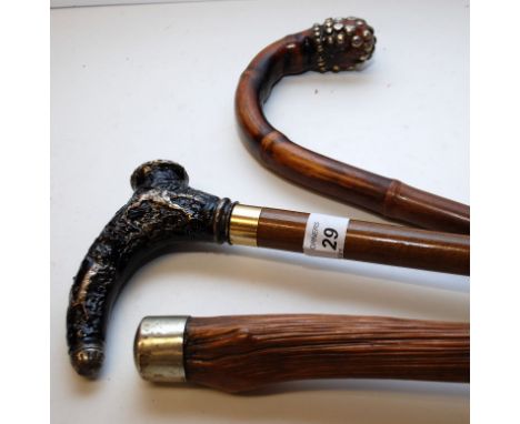 THREE WAKING CANES, EACH WITH WHITE METAL MOUNT DECORATION, ONE DEPICTING A HUNTING SCENE 