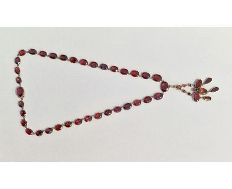 Victorian gold-coloured metal and garnet necklace with pendant drop, the oval graduated stones claw set with removable oval g