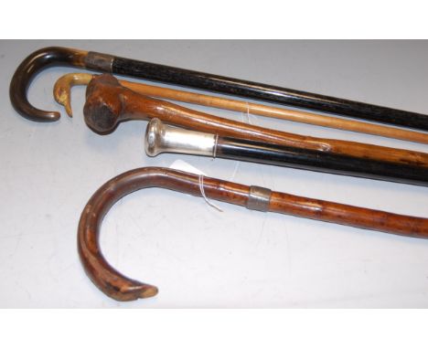 A Victorian walking stick, having ebony shaft and silver handle; together with four other walking sticks to include a horn ha