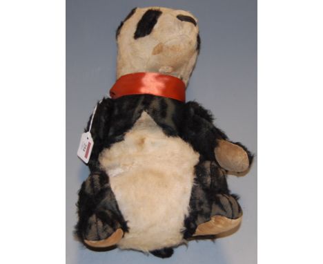 An early 20th century straw-filled mohair childs panda bear, with orange silk collar, heavily worn (possibly Steiff)