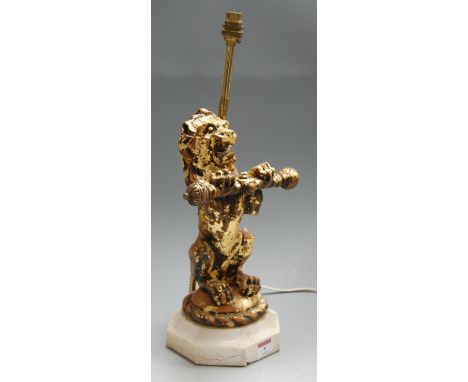 A late 20th century gilt resin figural table lamp in the form of a rampant lion holding a baton, on octagonal marble base, h.