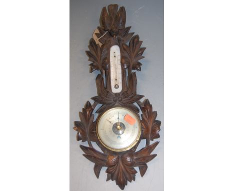 A late Victorian carved oak cased barometer