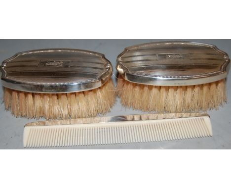 A pair of modern sterling silver brushes, with engine turned decoration, together with a matching comb, in fitted case