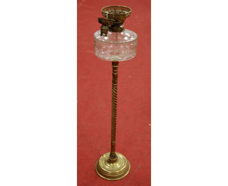 An early 20th century brass pedestal oil lamp, having clear cut glass font on spiral turned column, to platform base (later c