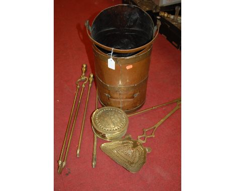 A copper coal scuttle, various turned brass fire tools, and a brass chestnut roaster