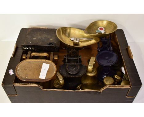 Five sets of metal and iron balance scales with assorted weights including bell shaped examples.