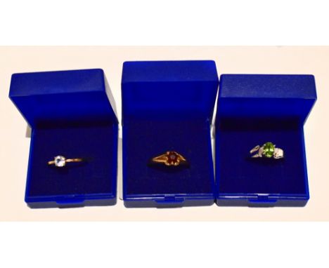 Two 9ct yellow gold dress rings including an example set with a garnet, size T 1/2, and a 9ct white gold dress ring set with 