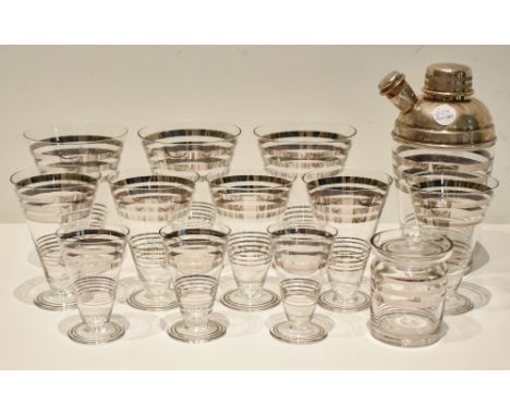 A 1950s Art Deco style twelve piece drinking set including cocktail shaker, eleven conical glasses, each with silver linear d