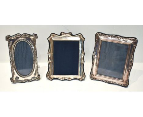 PAUL VERNON FITCHIE; two Elizabeth II hallmarked Britannia silver easel back photograph frames, each with cast scrolling deta