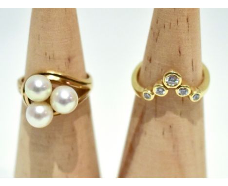 Two yellow metal dress rings comprising a V shaped example set with five clear stones, stamped 585, size L, and an example wi