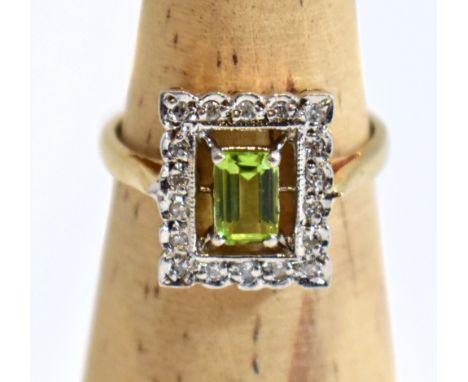 A modern 9ct yellow gold Art Deco style dress ring with emerald shaped peridot inside an illusion set band with clear stones,