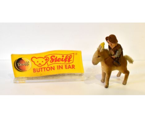 STEIFF; a 1950s model of a boy on horseback, height 18cm, and a modern Steiff advertising shop display plaque.Additional Info