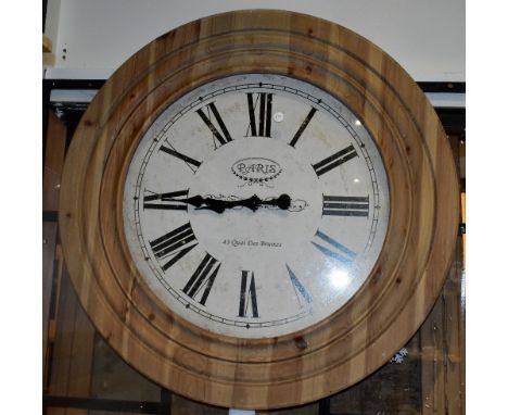 A modern pine framed wall clock with Roman numerals, printed Paris to the dial, diameter 75cm.