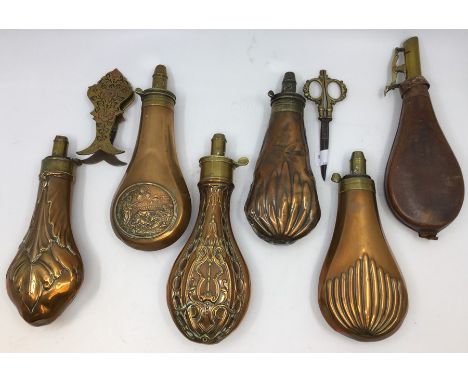 A collection of six various brass gun powder flasks, one with chased vignette on body depicting 18th Century shooting scene, 