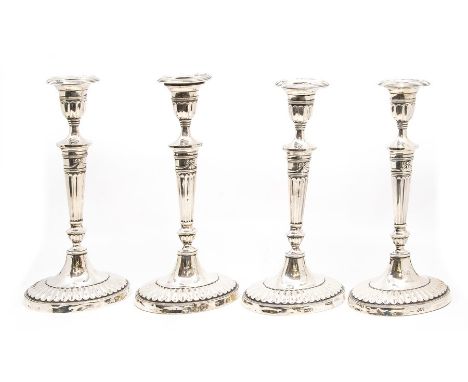 A set of four late Victorian silver candlesticks in the neo classical style, each with detachable sconces, trumpet shaped top