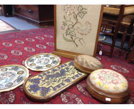 A Victorian mahogany framed firescreen with embroidered floral panel together with two circular foot rests (3)&nbsp;