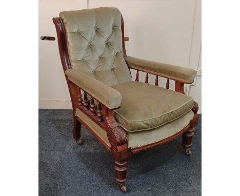A Victorian green button upholstered armchair with padded arms on balustrade supports, turned feet and castors