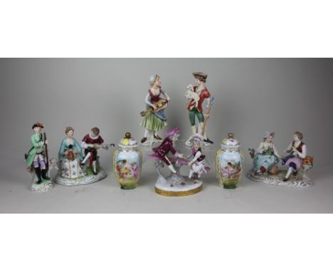 A Sitzendorf porcelain figure group of a seated couple with flowers and bird 13cm high, a pair of Goebel figures of a gentlem