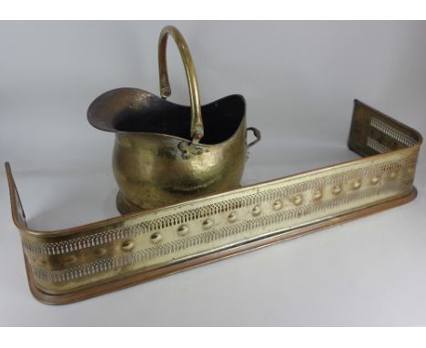 A brass helmet shaped coal scuttle and a pierced brass fire fender, 94cm