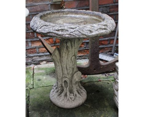 A composite bird bath with circular top on tree trunk effect pedestal stem 60cm high
