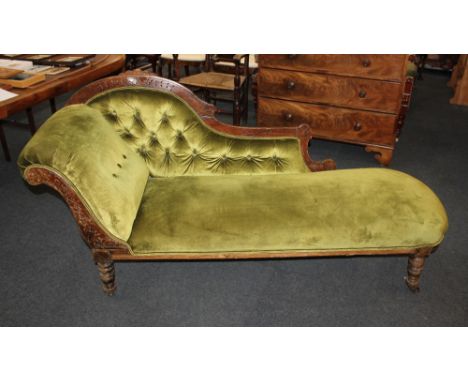 A Victorian chaise longue with green button upholstered back and carved wood frame, on turned legs and castors, 184cm