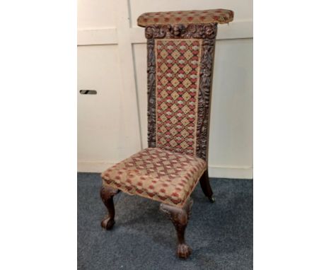 A Victorian Prie-dieu chair, carved with winged cherub and masks amongst flowers, fruit and scrolling foliage, with tapestry 