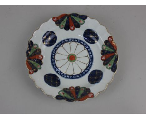 An 18th century Worcester porcelain plate with lobed rim, decorated in rust, green and blue, with gilt embellishments, 19cm d