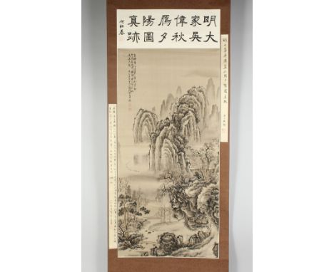 A CHINESE SCROLL PAINTING ON SILK depicting a mountainous landscape with buildings and trees, with inscription to the top-lef