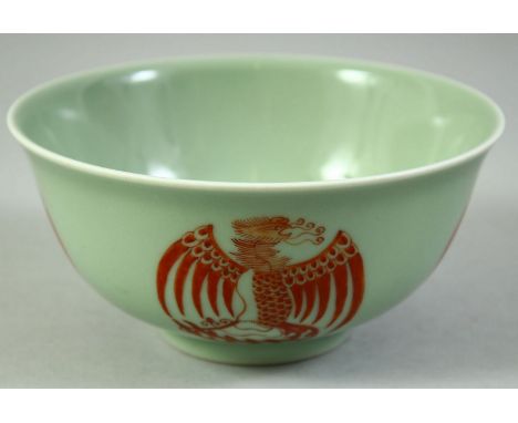 A CHINESE CELADON GLAZED PORCELAIN BOWL, painted in copper red with phoenix, the base with siz character mark, 14.5cm diamete