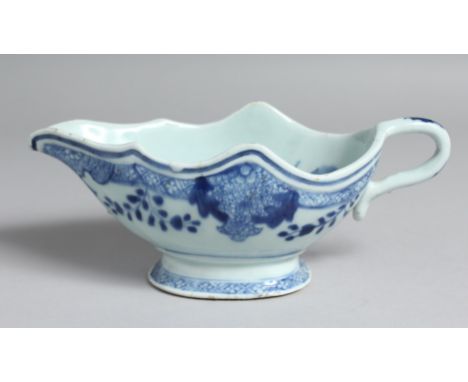 A CHINESE BLUE AND WHITE PORCELAIN SAUCE BOAT, the interior decorated with native flora. 21cm long