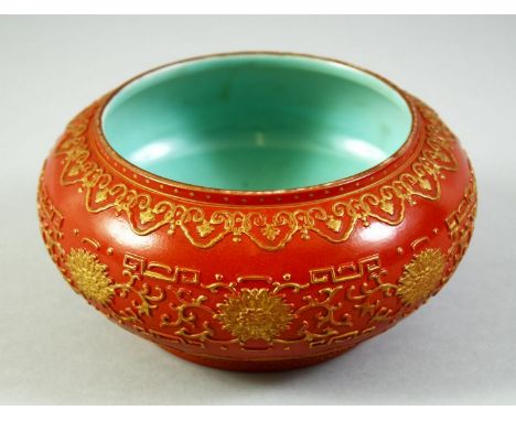 A CHINESE RED GROUND PORCELAIN BOWL, with raised gilt decoration, the interior and base with turquoise, impressed six charact