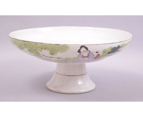 A CHINESE PORCELAIN PEDESTAL DISH / FRUIT BOWL, painted with two seated figures next to a tree, 23cm diameter.