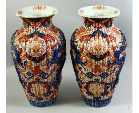 A LARGE PAIR OF JAPANESE IMARI PORCELAIN VASES, each with ribbed body and raised dragon decoration, 46cm high.