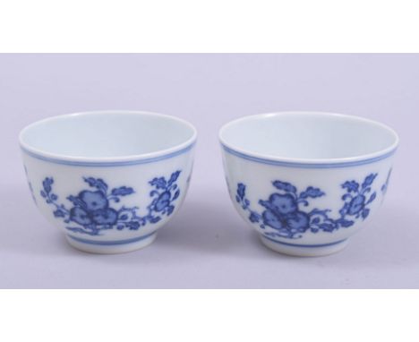 A GOOD PAIR OF CHINESE BLUE AND WHITE PORCELAIN TEA BOWLS, the exterior of each painted with floral sprays, both bases with s