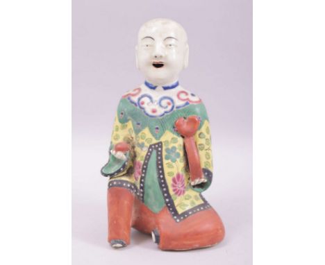 A CHINESE REPUBLIC FAMILLE VERTE PORCELAIN FIGURE OF A BOY holding a peach, 19cm high.