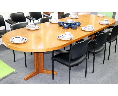 A 1970s Danish style teak extending dining table, possibly by Glostrup or Dyrland, on twin pillar tripod base with two extra 