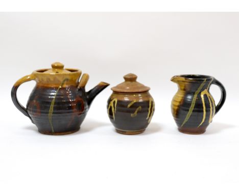 Studio Pottery, a three-piece tea service of dark glaze with yellow and rust trailing designs