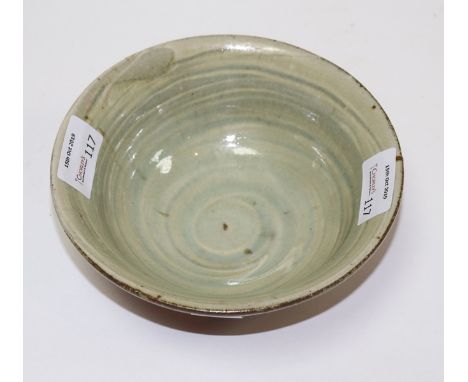 Mike Dodd (British, born 1943), a circular stoneware bowl with rust coloured glazed exterior and celadon swirled interior, in