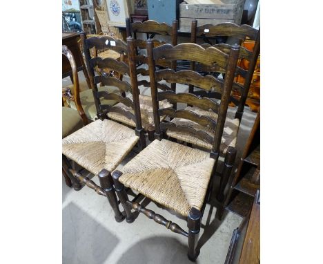 A set of 4 oak ladder back rush seated dining chairs.